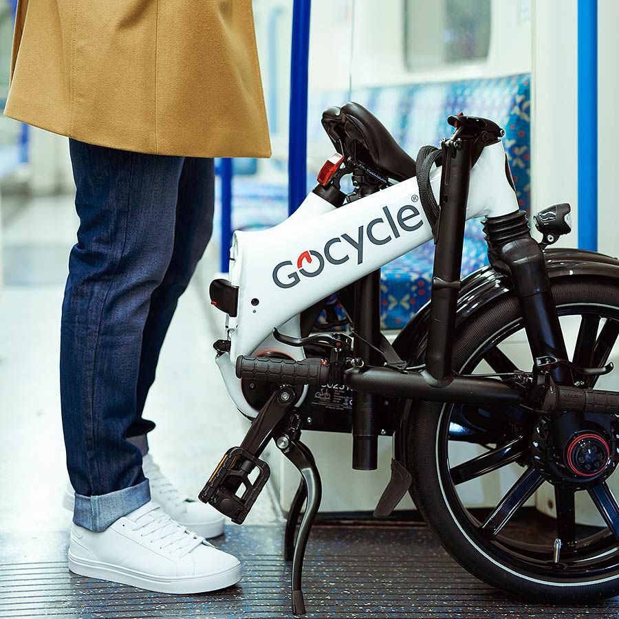Persona plegando bicicleta eléctrica Gocycle G4i en una oficina