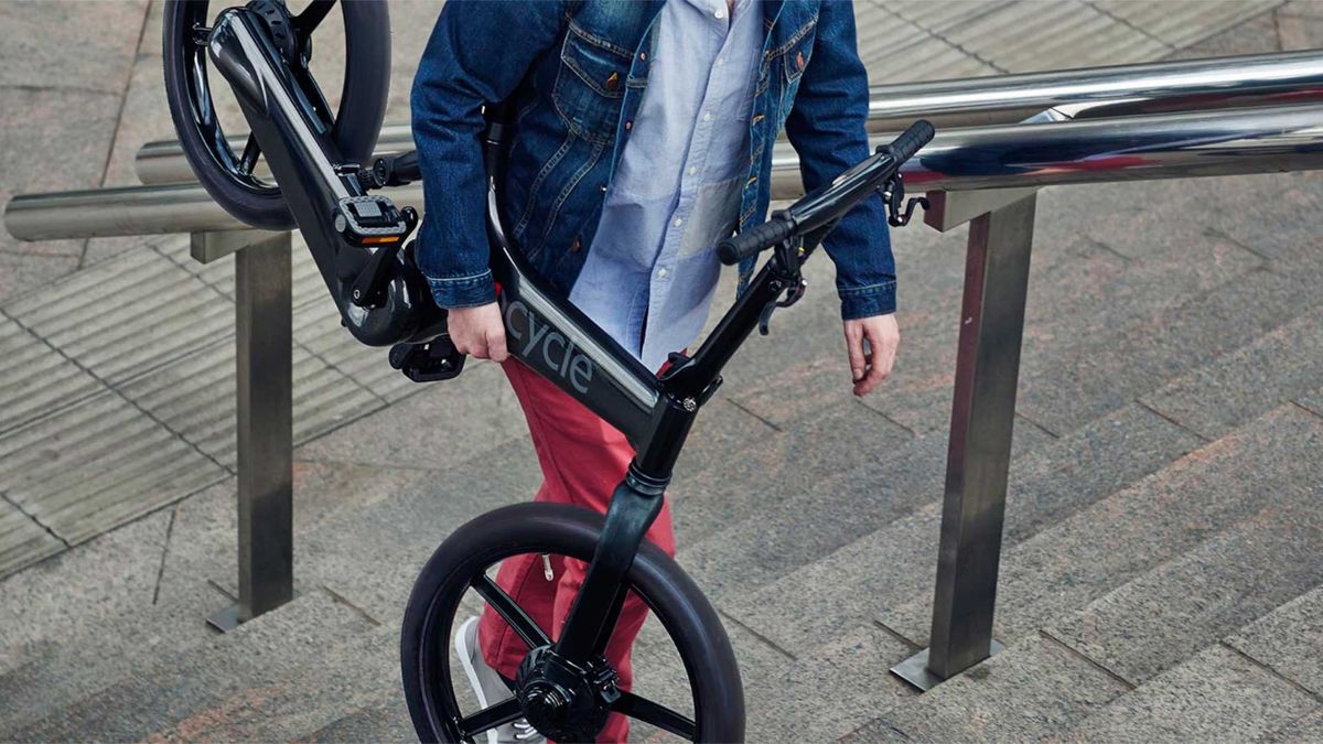 Ciclista subiendo una bicicleta ligera por las escaleras del metro.