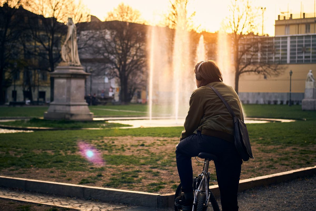 Ciclista urbano escuchando música mientras pedalea en un parque