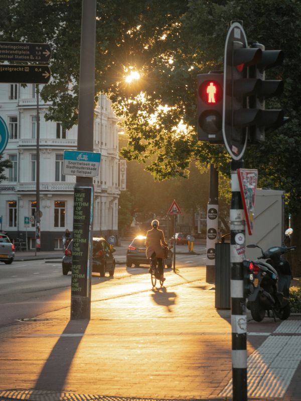 Ciclista en ebike por una calle urbana al atardecer