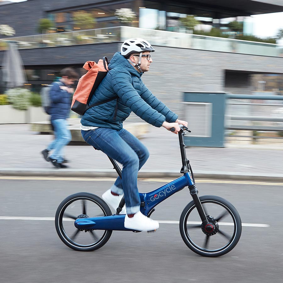 Ciclista en bicicleta eléctrica recorriendo una ciudad